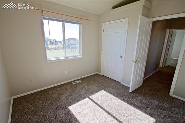 8461 Saddleman Road Peyton, CO 80831 - Photo 13 of 26 Bedroom #2 on upper level features vaulted ceiling, 6 panel doors, window coverings