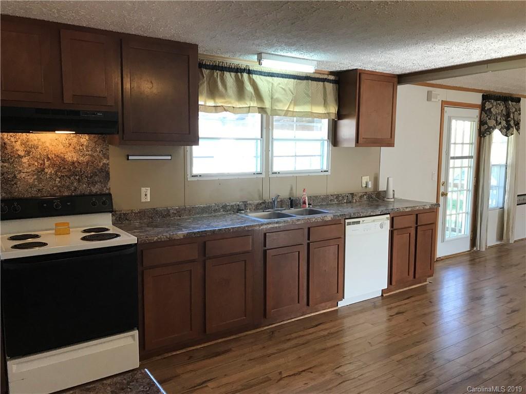 124 Fair Share Road Salisbury, NC 28147 - Photo 12 of 33 a kitchen with granite countertop wooden cabinets a stove and a window