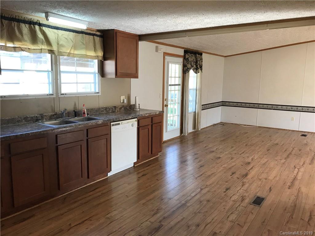 124 Fair Share Road Salisbury, NC 28147 - Photo 13 of 33 a kitchen with stainless steel appliances granite countertop a sink cabinets and wooden floor