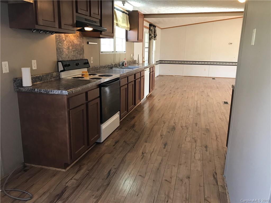 124 Fair Share Road Salisbury, NC 28147 - Photo 19 of 33 a kitchen with kitchen island granite countertop wooden floors and stainless steel appliances