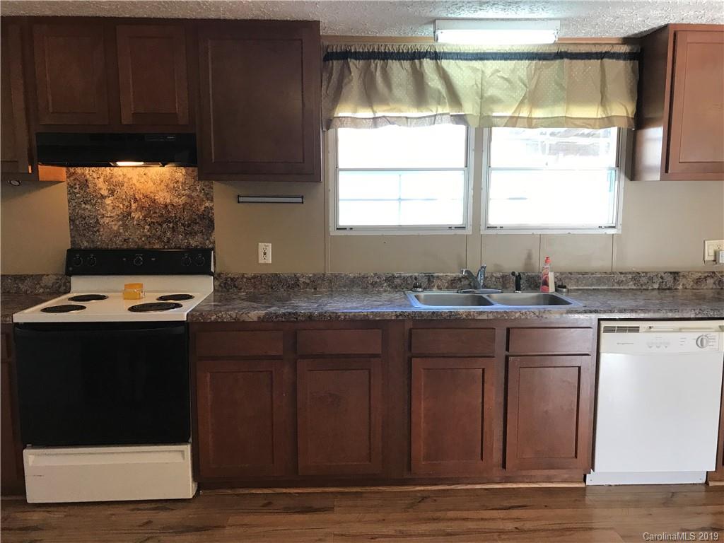 124 Fair Share Road Salisbury, NC 28147 - Photo 21 of 33 a kitchen with granite countertop a sink cabinets and wooden floor