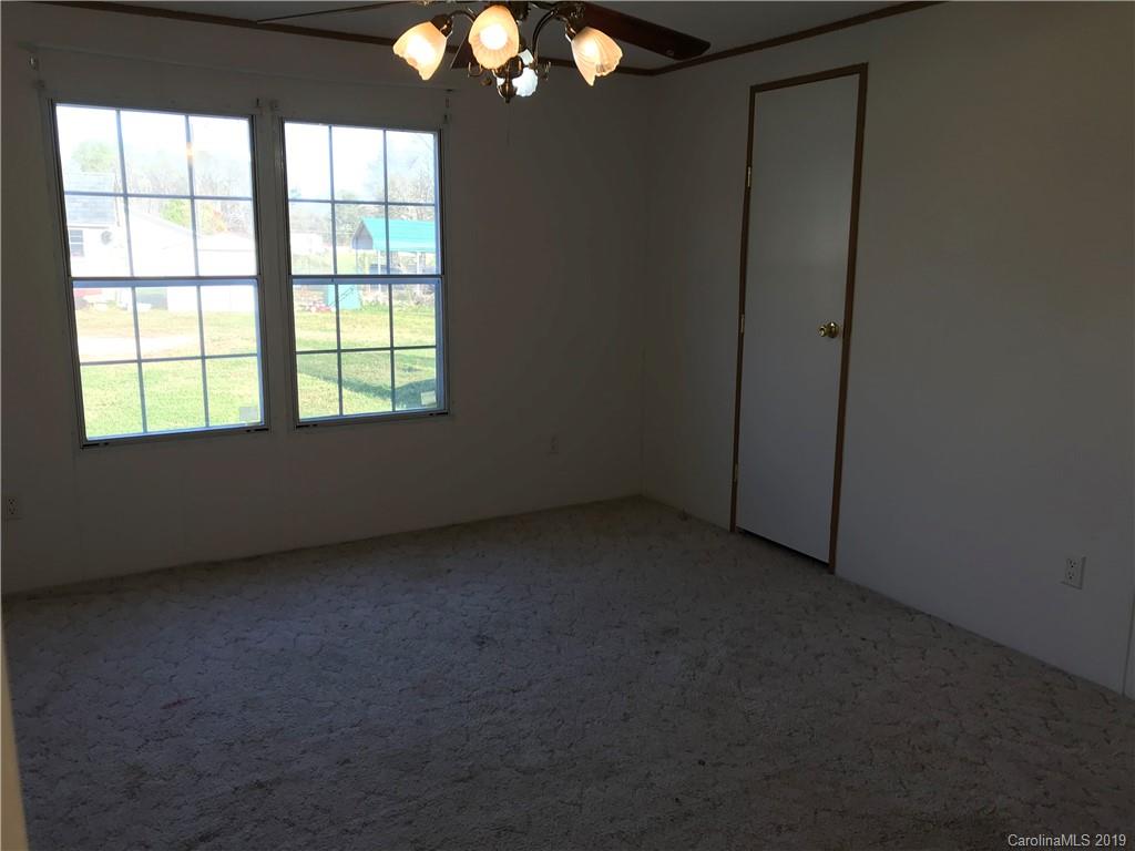 124 Fair Share Road Salisbury, NC 28147 - Photo 25 of 33 an empty room with chandelier fan and windows