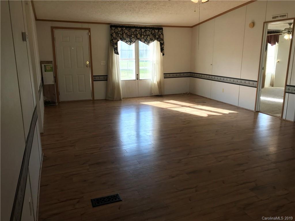 124 Fair Share Road Salisbury, NC 28147 - Photo 4 of 33 an empty room with wooden floor and windows