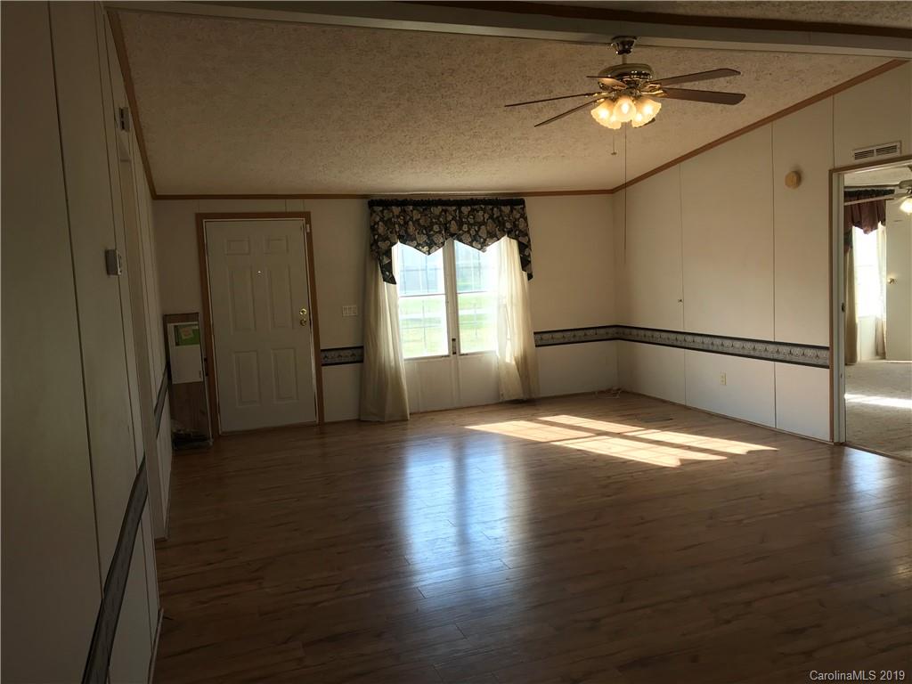 124 Fair Share Road Salisbury, NC 28147 - Photo 6 of 33 an empty room with wooden floor and windows