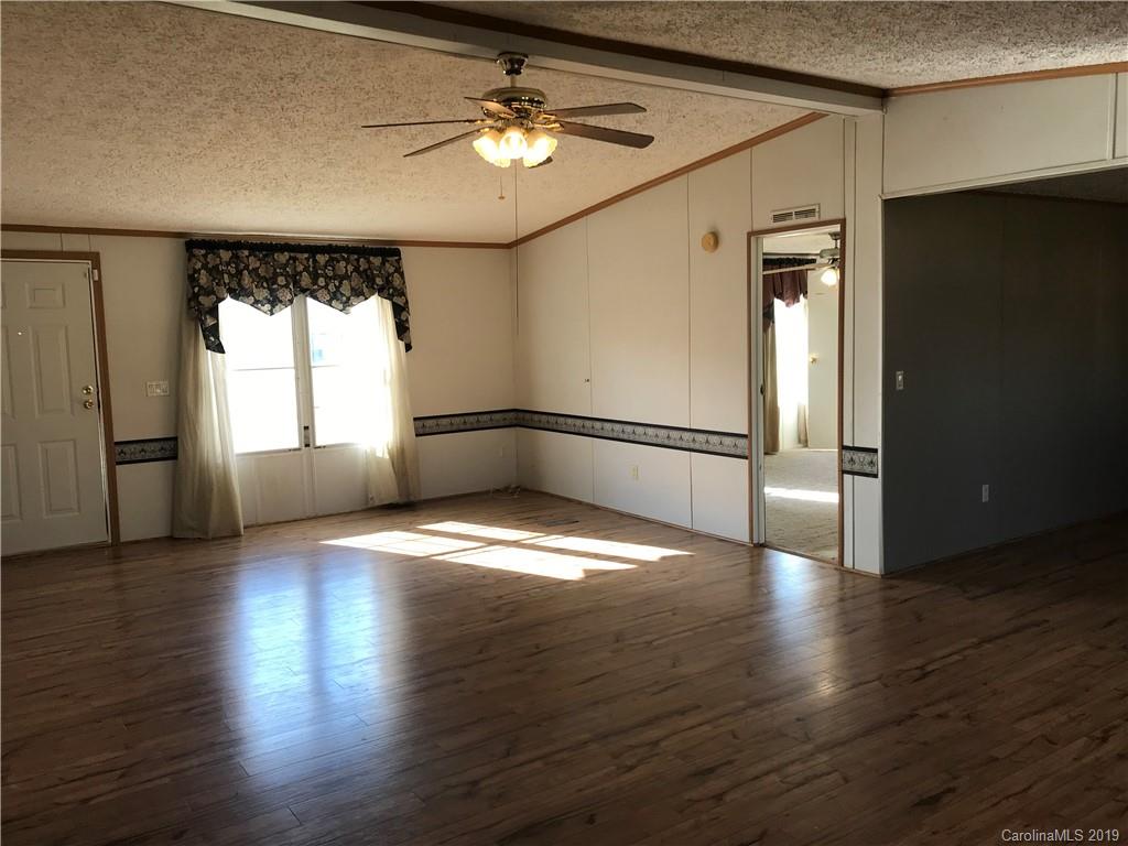 124 Fair Share Road Salisbury, NC 28147 - Photo 7 of 33 an empty room with wooden floor and windows
