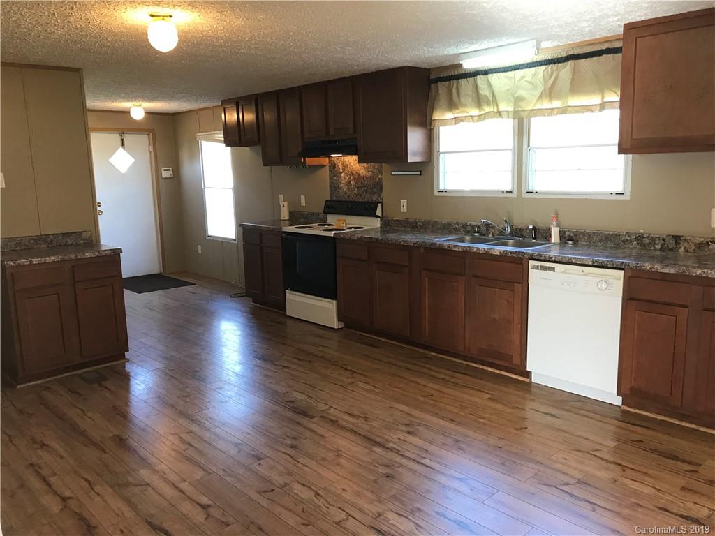 124 Fair Share Road Salisbury, NC 28147 - Photo 10 of 33 a kitchen with granite countertop wooden floors and black stainless steel appliances