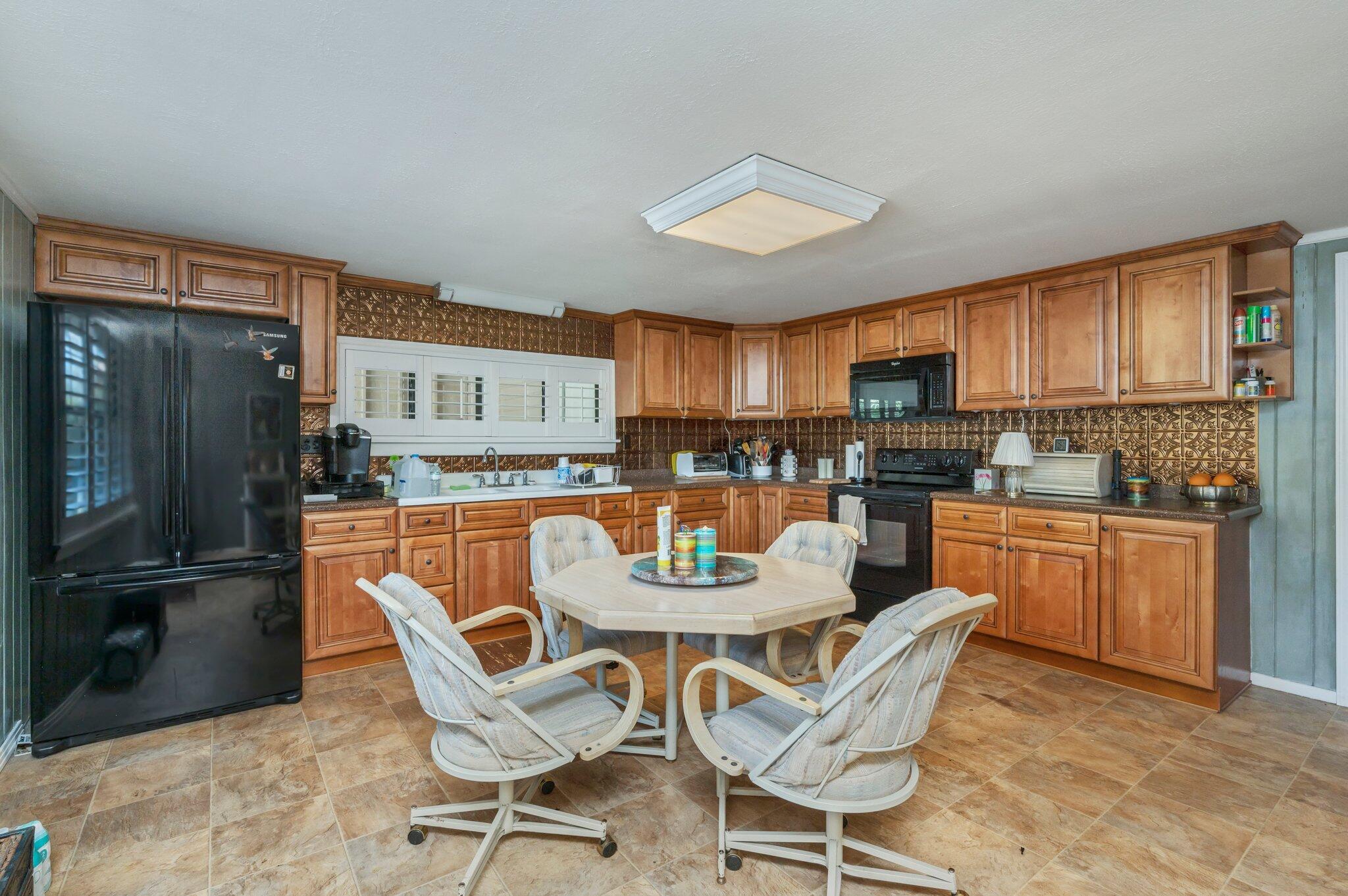 7068 Old River Road Baker, FL 32531 - Photo 13 of 42 a dining room with a table chairs and a kitchen view