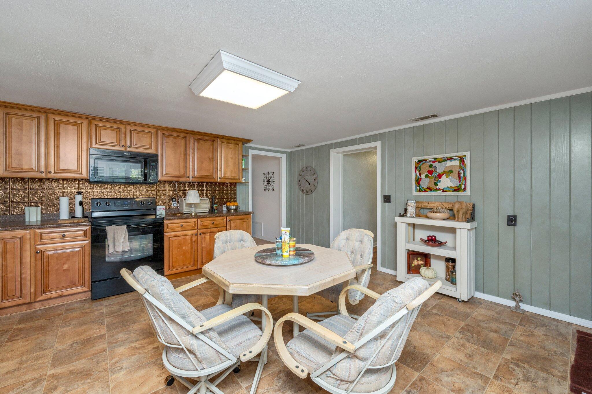 7068 Old River Road Baker, FL 32531 - Photo 16 of 42 a kitchen with a refrigerator a stove a dining table and chairs