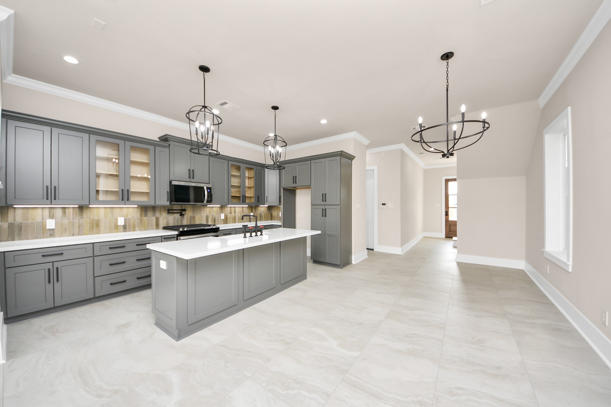 6320 Milwee Street, Unit A Houston, TX 77092 - Photo 13 of 42 a large kitchen with kitchen island a chandelier stainless steel appliances cabinets and a counter top space