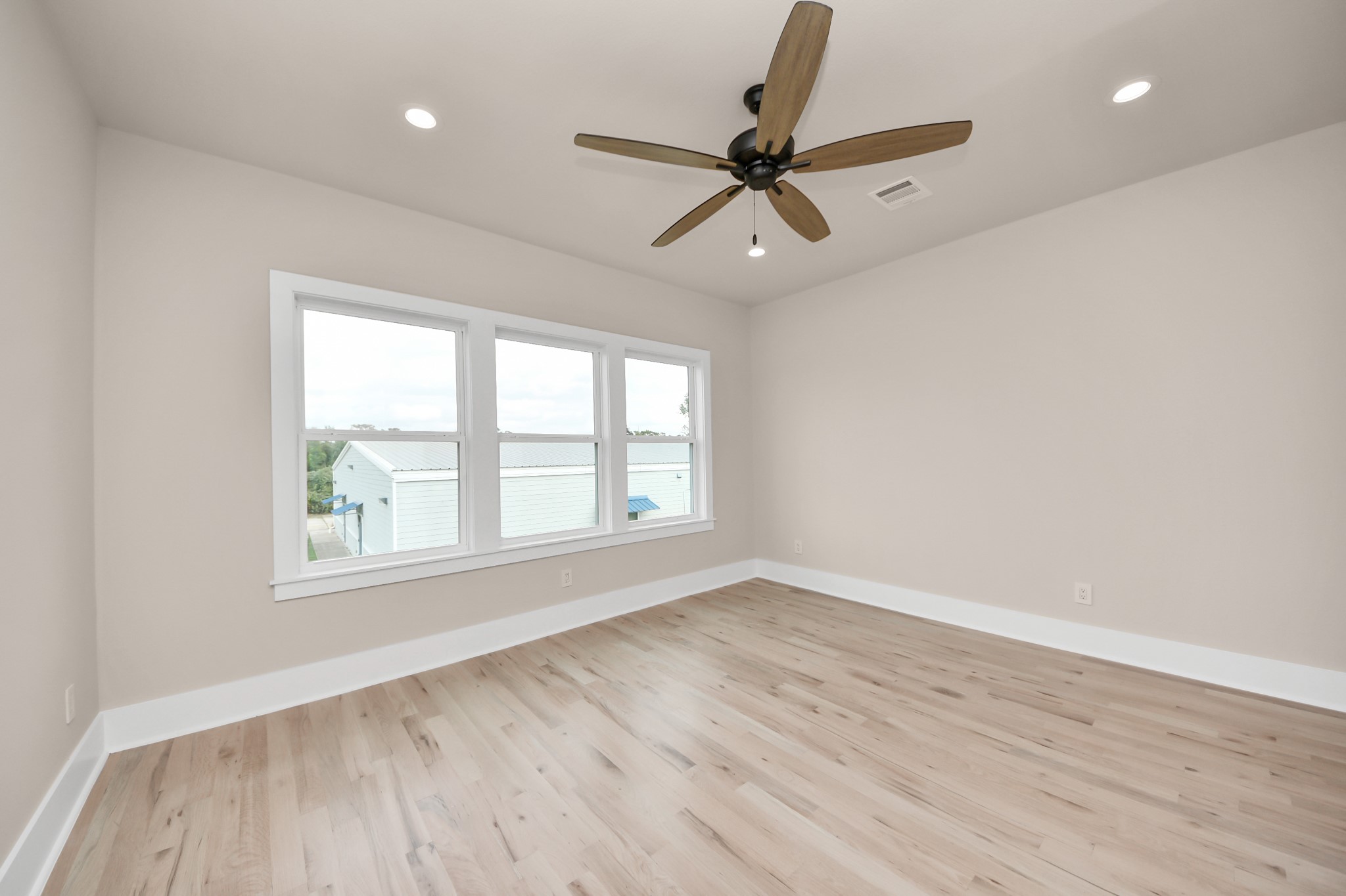 6320 Milwee Street, Unit A Houston, TX 77092 - Photo 34 of 42 an empty room with wooden floor fan and windows
