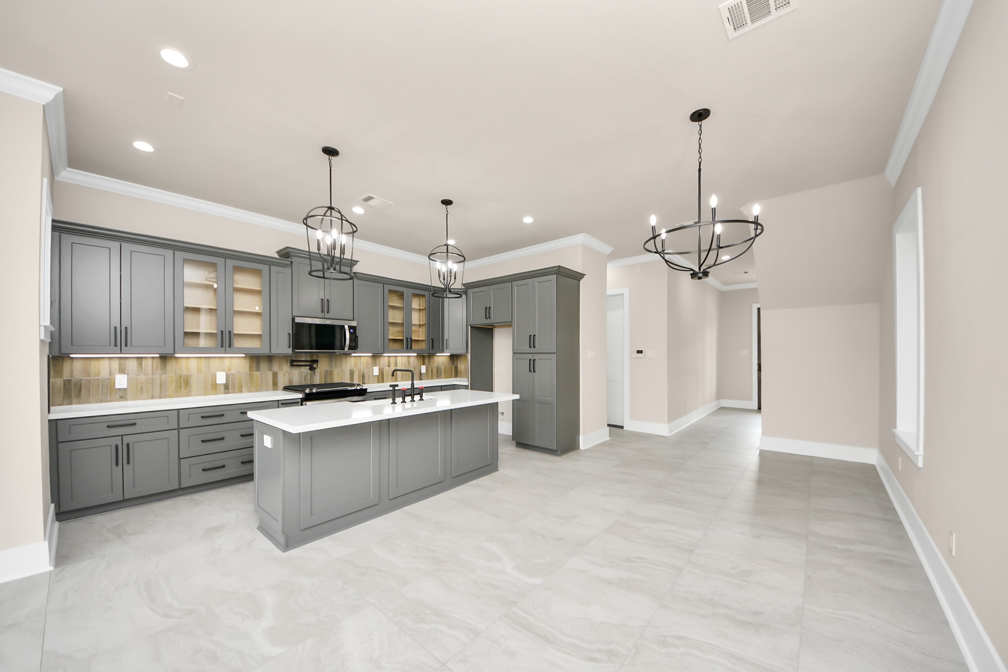 6320 Milwee Street, Unit A Houston, TX 77092 - Photo 10 of 42 a large kitchen with kitchen island a sink stainless steel appliances and cabinets