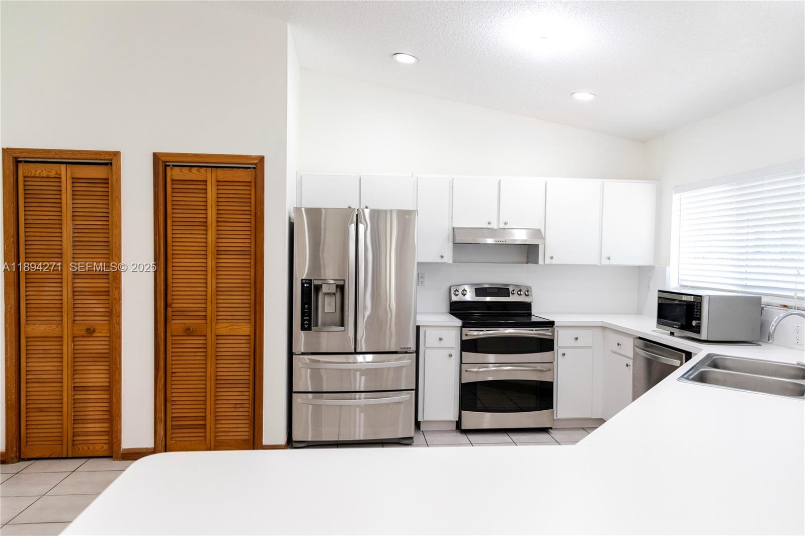 8192 Southwest 90th Avenue Miami, FL 33173 - Photo 13 of 31 a kitchen with stainless steel appliances a refrigerator and a stove top oven