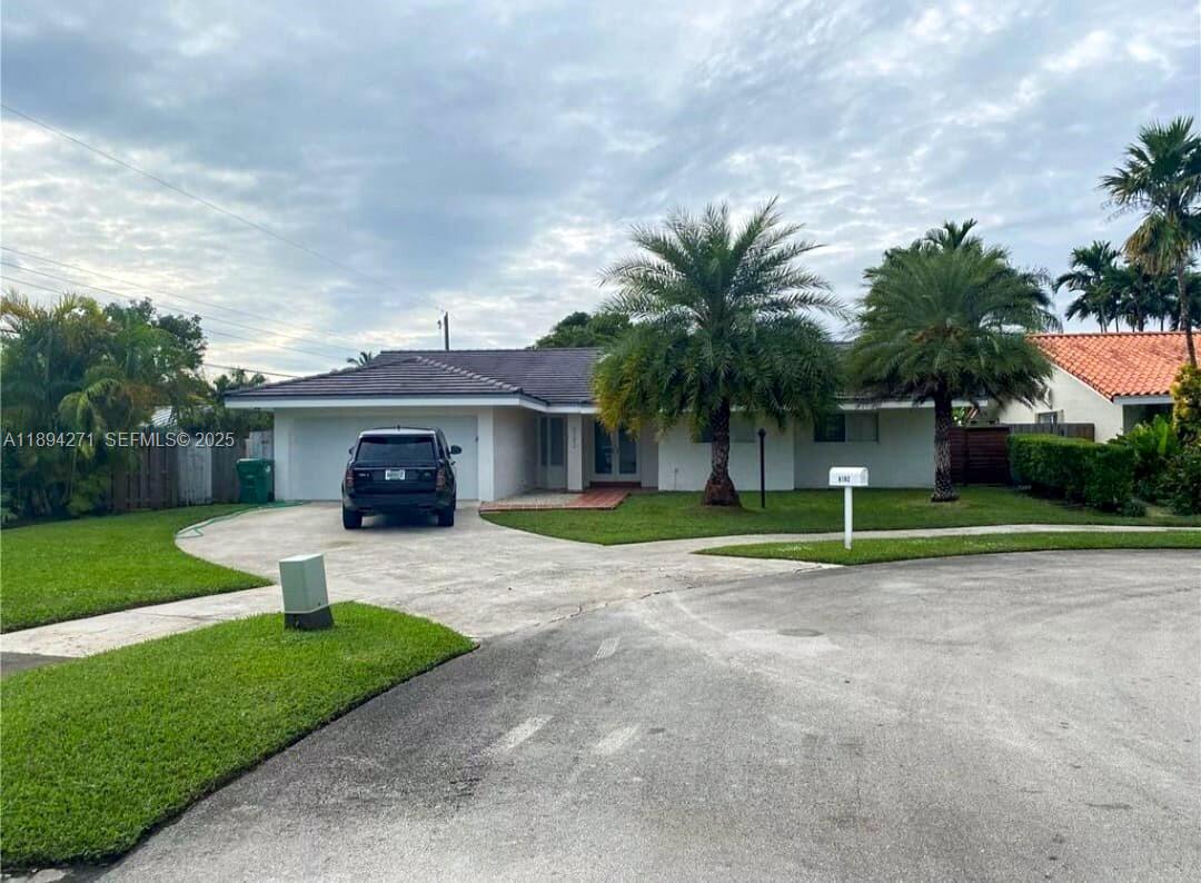 8192 Southwest 90th Avenue Miami, FL 33173 - Photo 2 of 31 a view of a house with a yard and a car park