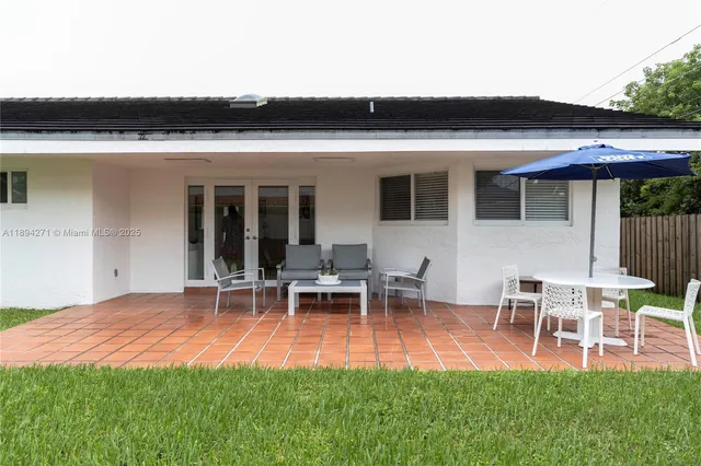 a view of a house with patio and a yard