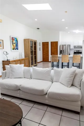 a living room with furniture and kitchen view