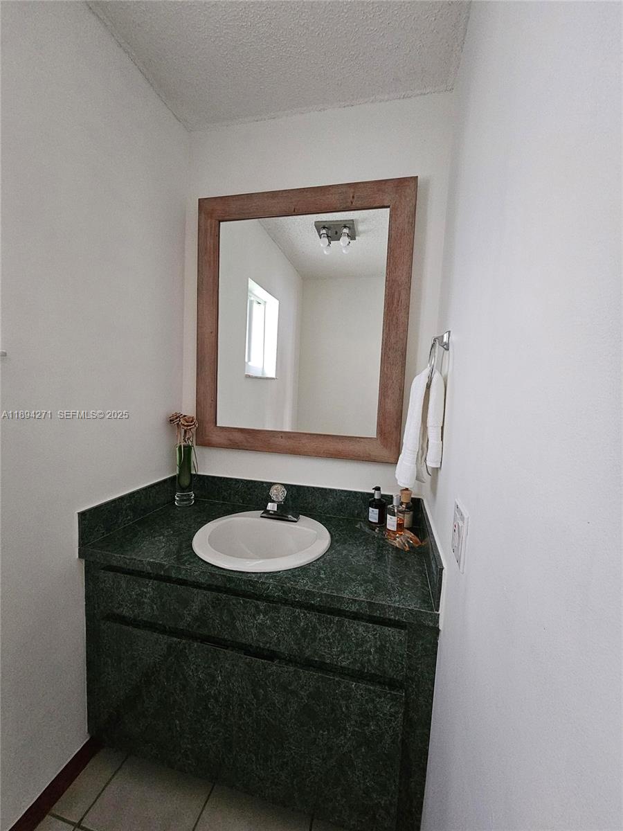 8192 Southwest 90th Avenue Miami, FL 33173 - Photo 10 of 31 a bathroom with a granite countertop sink and a mirror