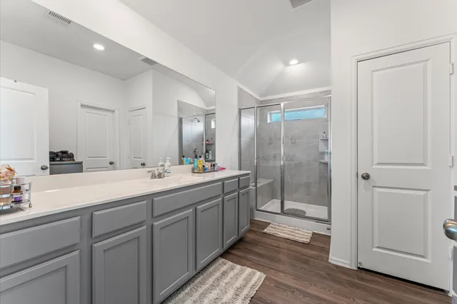 a bathroom with a double vanity sink mirror and shower