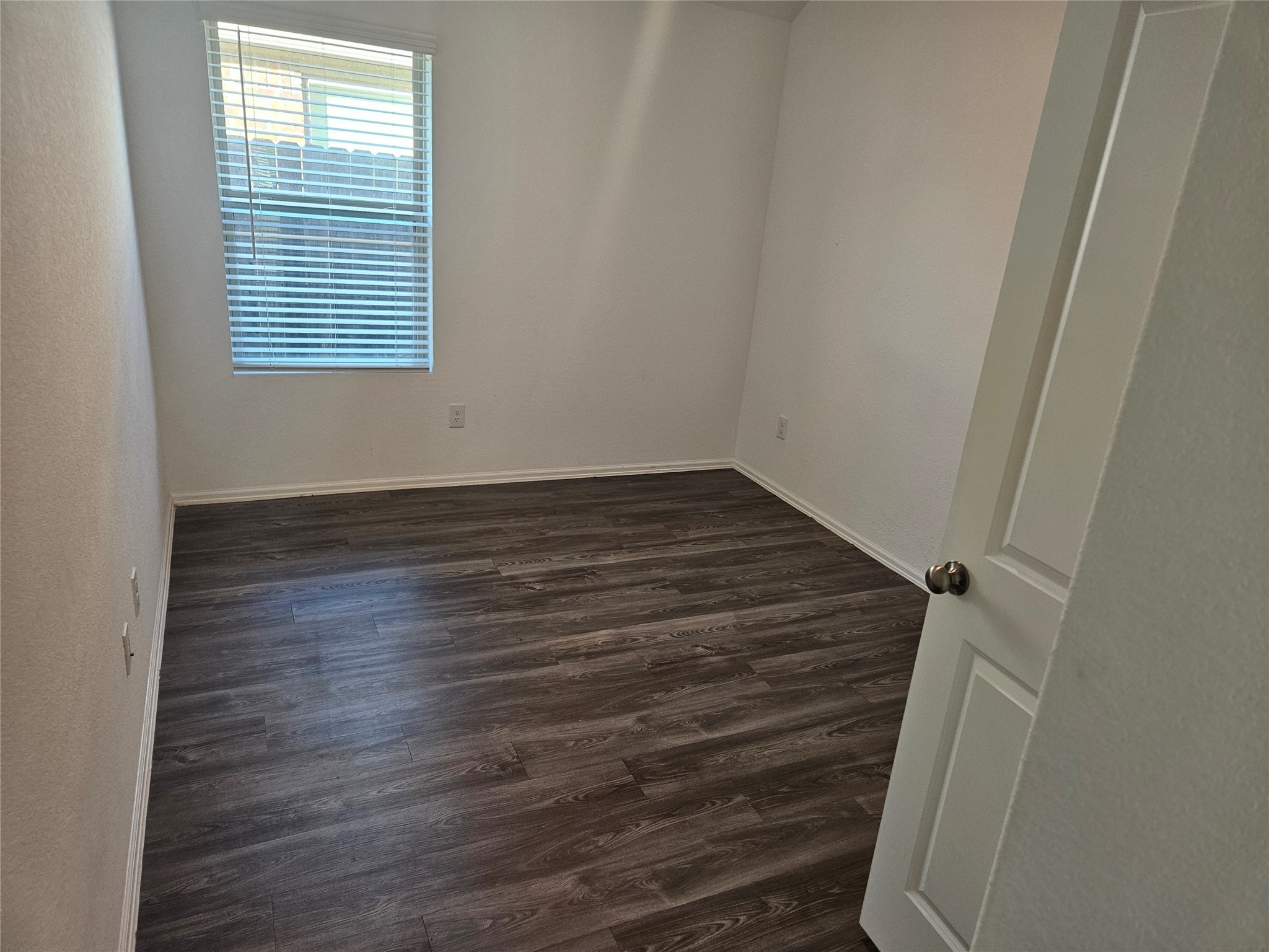 4926 Lenox Grv Lane Rosharon, TX 77583 - Photo 17 of 26 a view of an empty room with wooden floor and a window