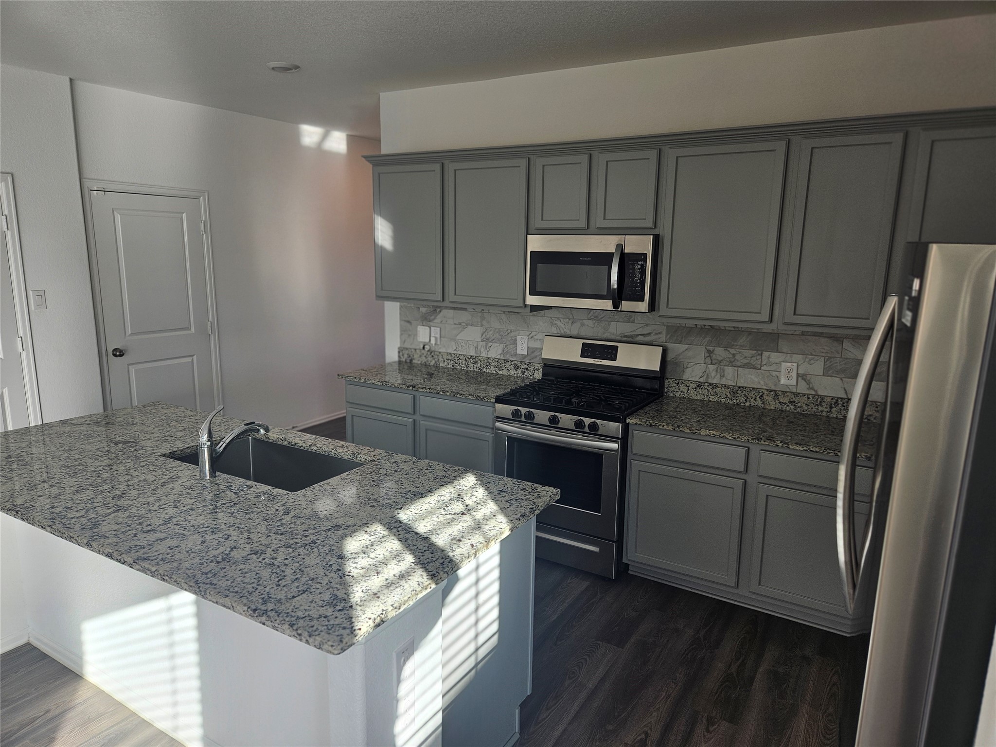 4926 Lenox Grv Lane Rosharon, TX 77583 - Photo 9 of 26 a kitchen with granite countertop a sink stove and refrigerator
