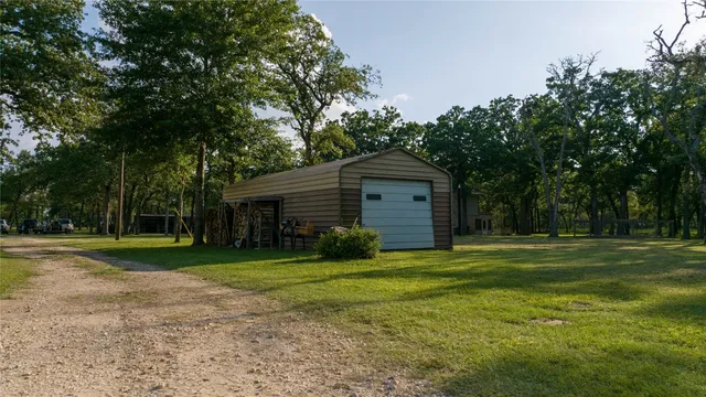 a front view of a house with a yard and trees