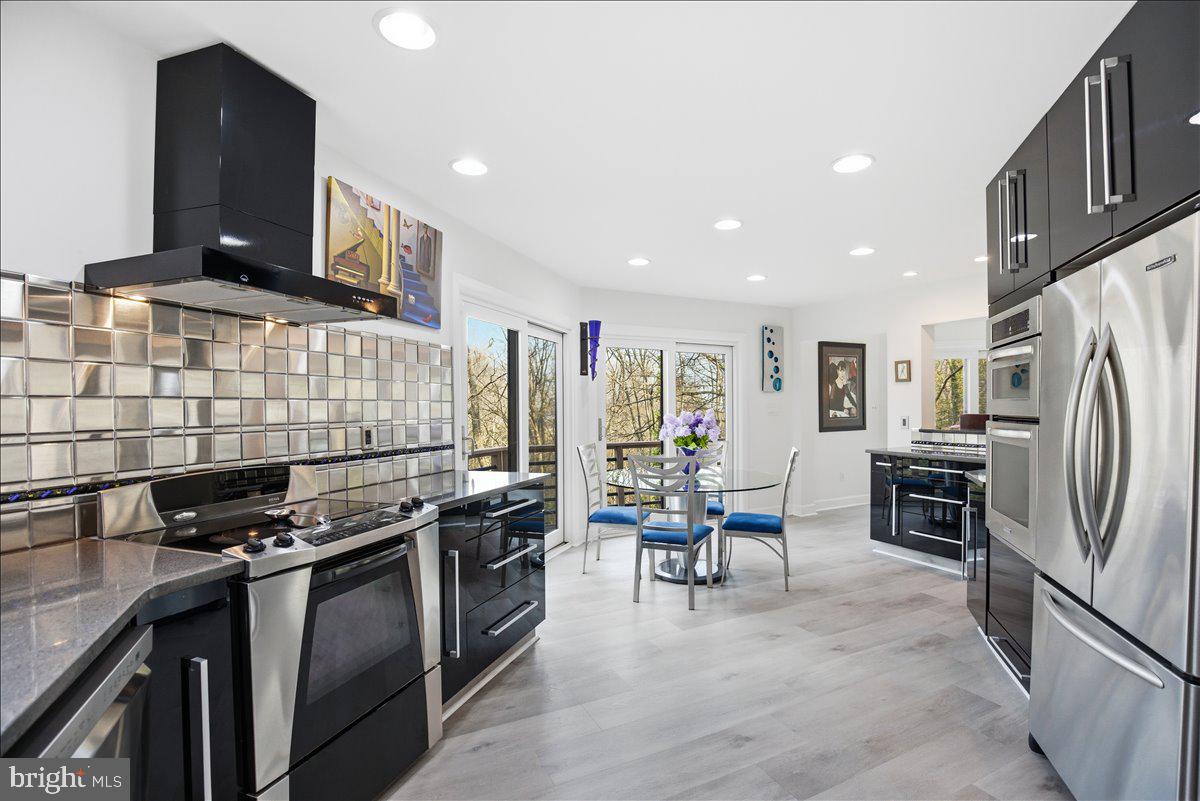 1142 Ranger Ridge Road Lusby, MD 20657 - Photo 19 of 53 a kitchen with stainless steel appliances granite countertop a stove top oven a sink a refrigerator and chairs