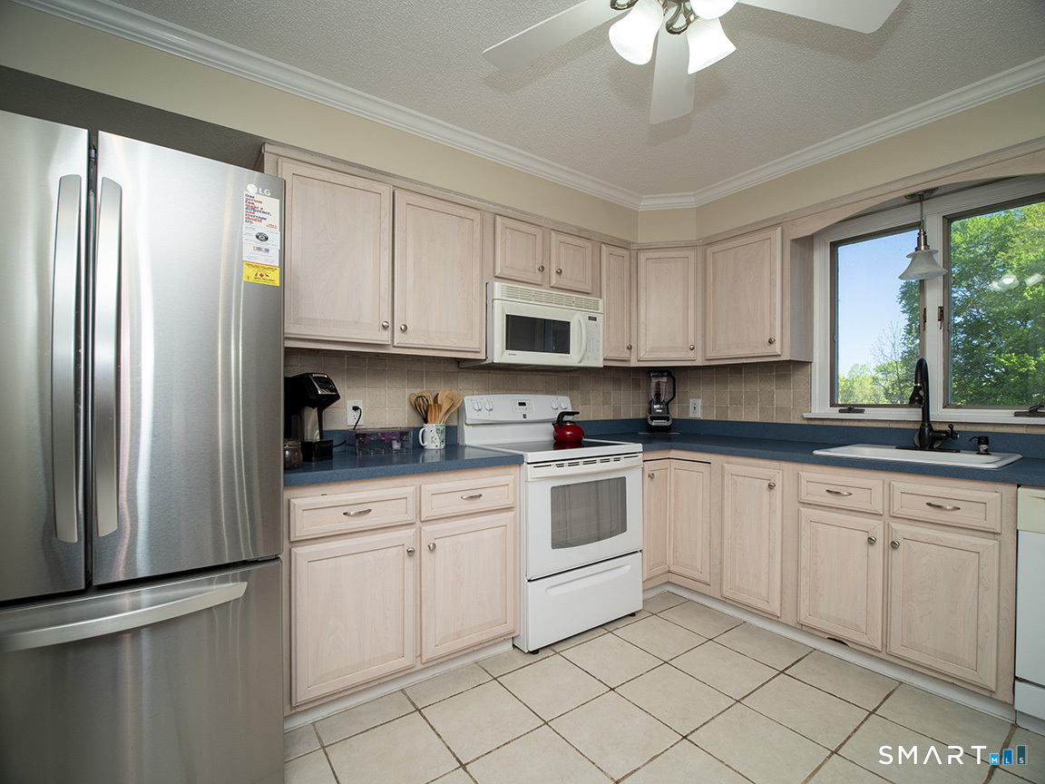 82 Wilcox Road Middletown, CT 06457 - Photo 17 of 27 a kitchen with white cabinets stainless steel appliances a sink and a window