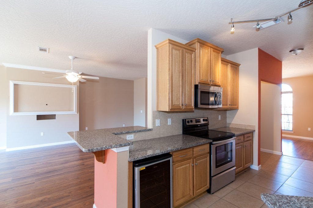 4625 Hermosa Road Crestview, FL 32539 - Photo 11 of 37 a kitchen with stainless steel appliances granite countertop a sink a stove and a wooden floor