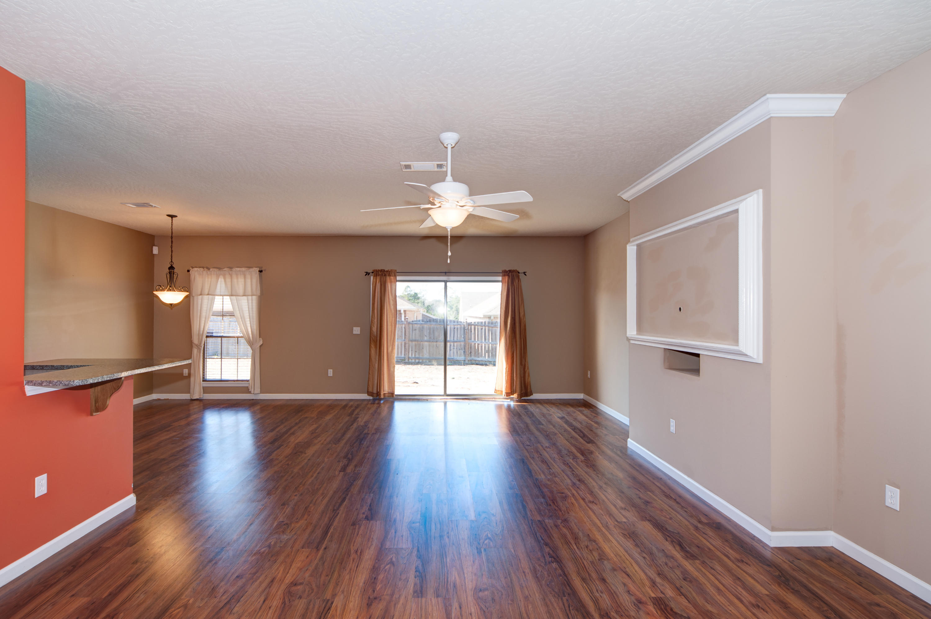 4625 Hermosa Road Crestview, FL 32539 - Photo 3 of 37 a view of an empty room with wooden floor and a window