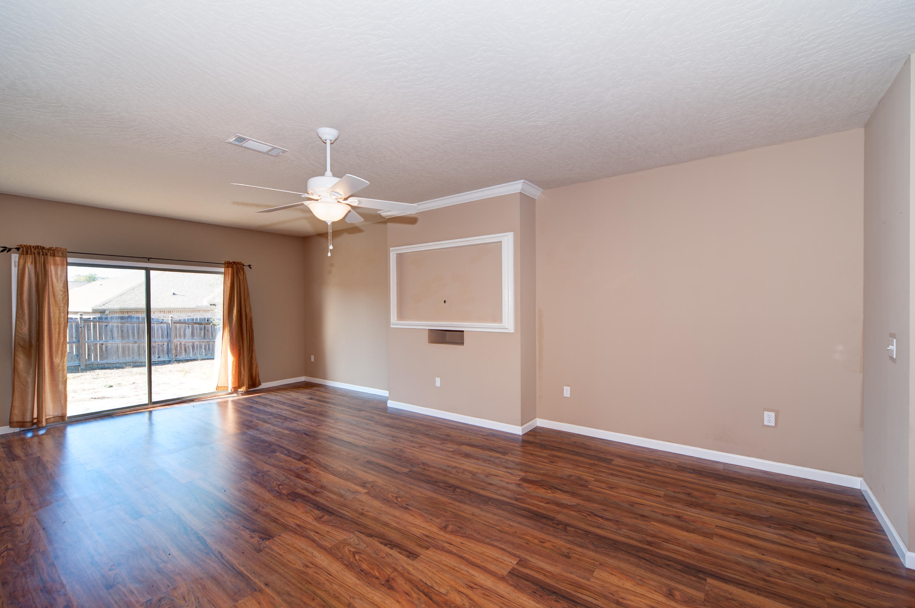 4625 Hermosa Road Crestview, FL 32539 - Photo 4 of 37 a view of an empty room with window and wooden floor