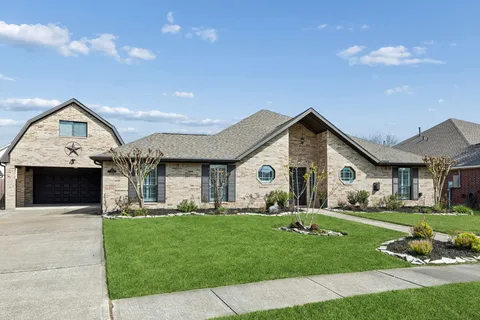 a front view of a house with a garden and yard
