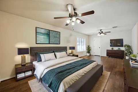 a spacious bedroom with a bed and a chandelier