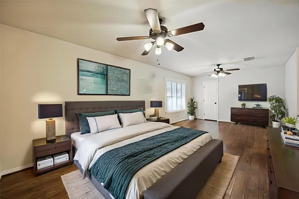 a spacious bedroom with a bed and a chandelier
