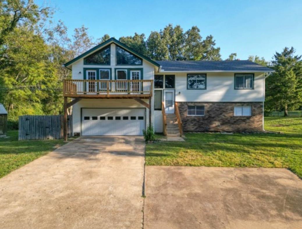 View of front of house with a garage and a front lawn