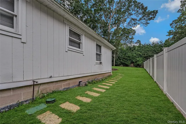 a backyard of a house with plants and tree