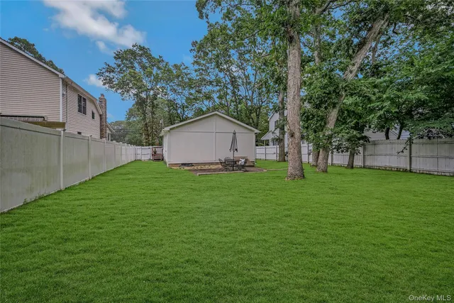 a view of a backyard with a small cabin and wooden fence
