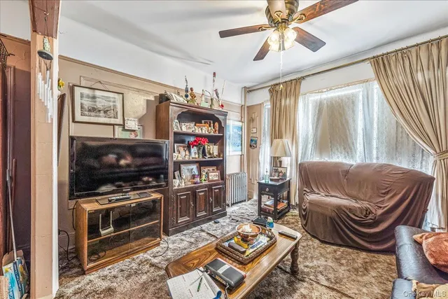 a living room with furniture a flat screen tv and a window