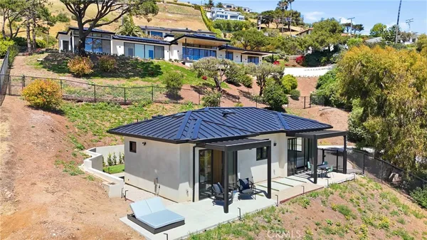 a view of a house with backyard sitting area and garden