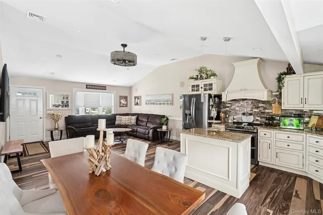 a kitchen with stainless steel appliances granite countertop a stove and white cabinets