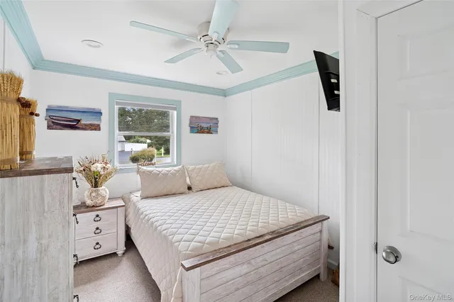 a bedroom with a bed a flat screen tv and dresser