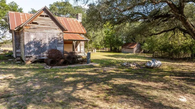 a view of a house with backyard and sitting area