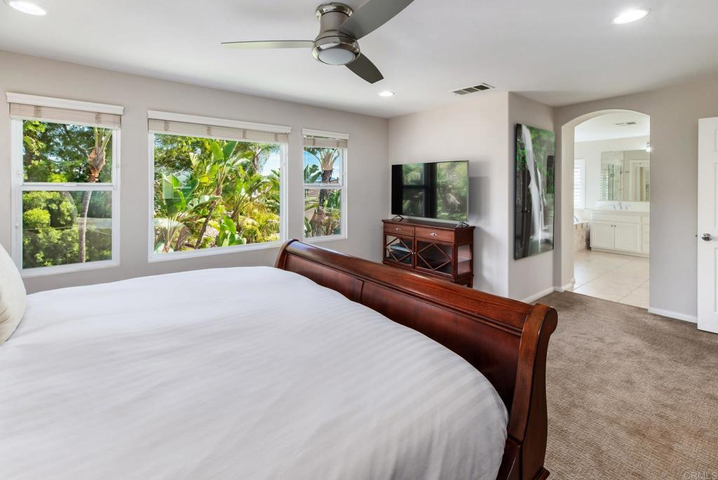 3434 Ravine Drive Carlsbad, CA 92010 - Photo 15 of 37 a bedroom with a large bed and a flat tv screen