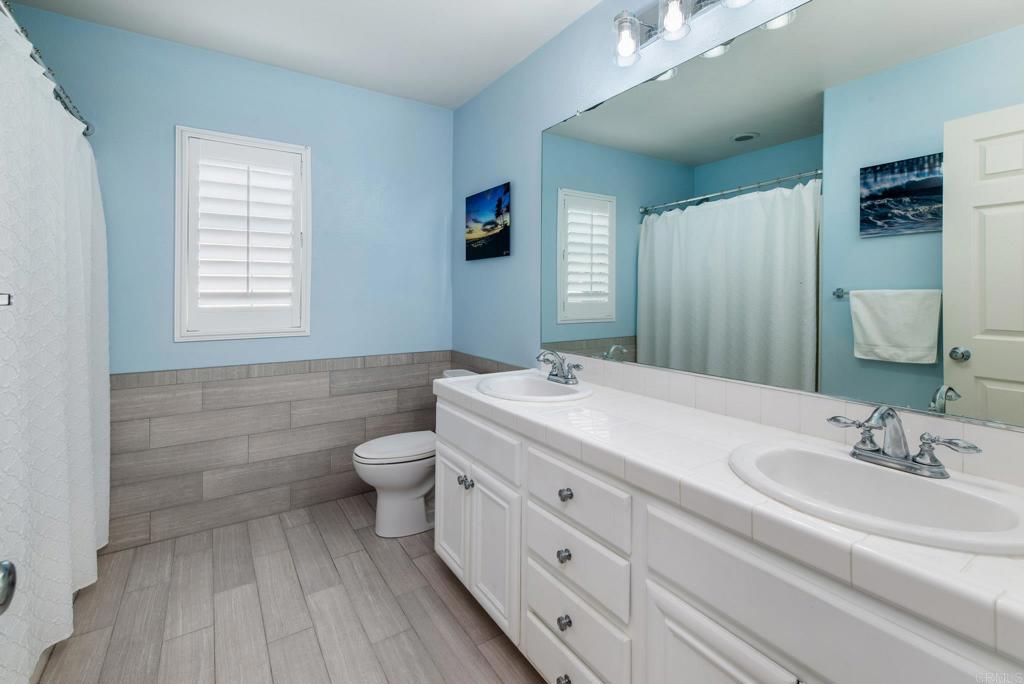 3434 Ravine Drive Carlsbad, CA 92010 - Photo 19 of 37 a bathroom with a double vanity sink toilet and a mirror