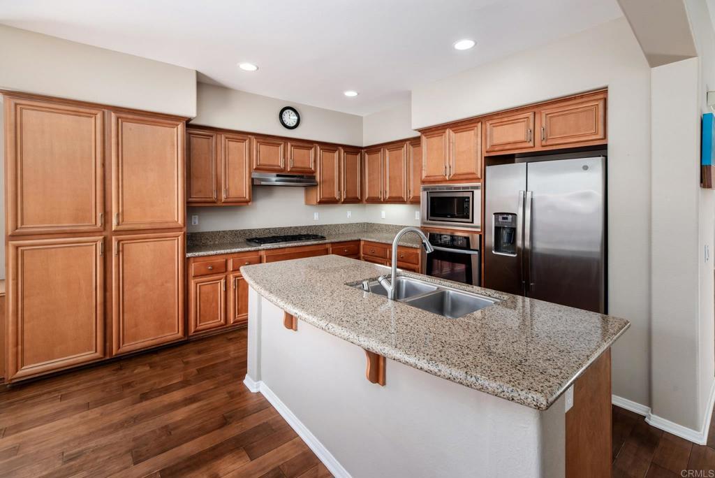 3434 Ravine Drive Carlsbad, CA 92010 - Photo 9 of 37 a kitchen with kitchen island granite countertop a sink and refrigerator