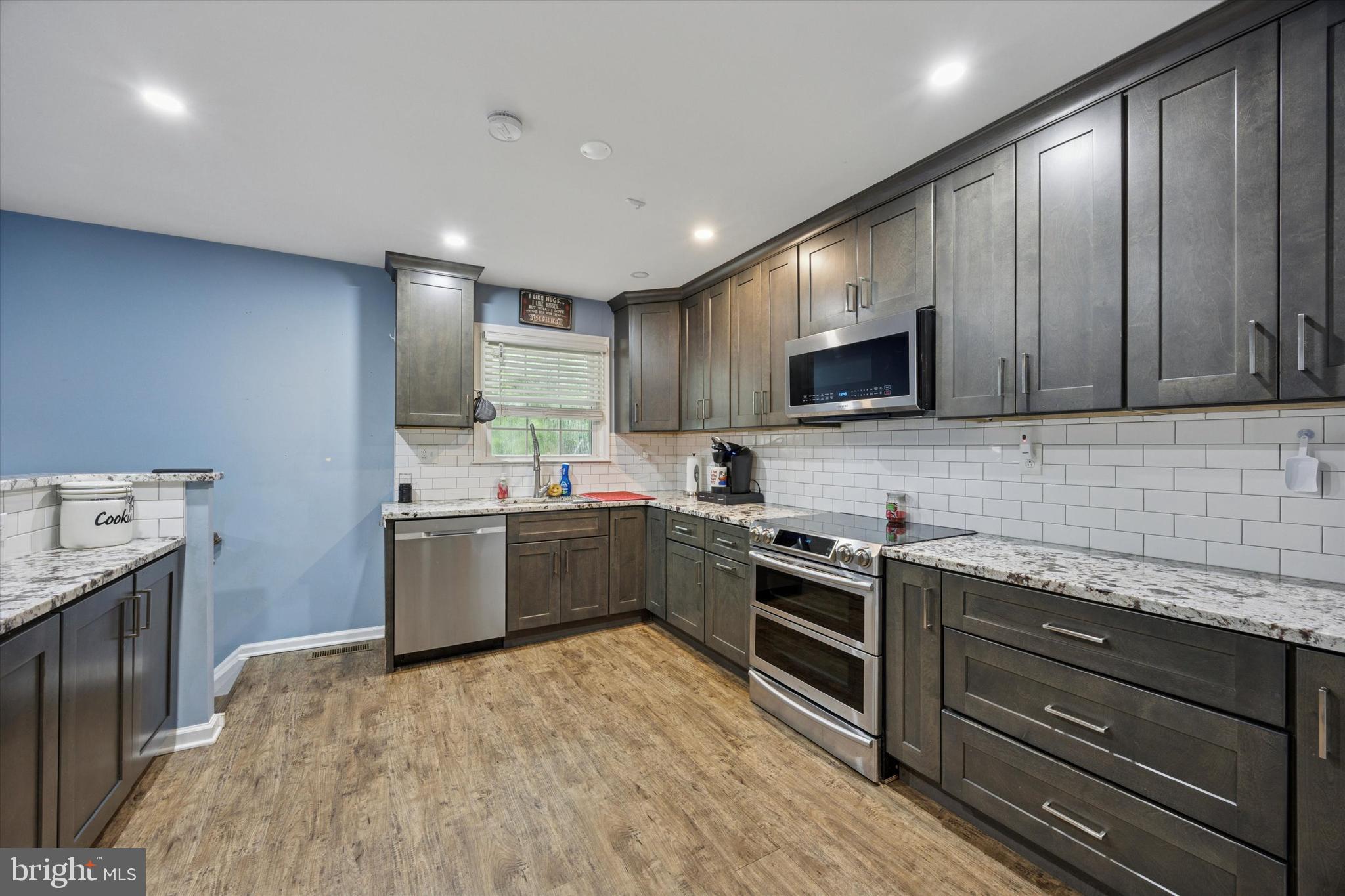 37 Millbrook Road Newark, DE 19713 - Photo 3 of 17 a kitchen with stainless steel appliances granite countertop wooden cabinets a sink dishwasher a stove and a refrigerator with wooden floor