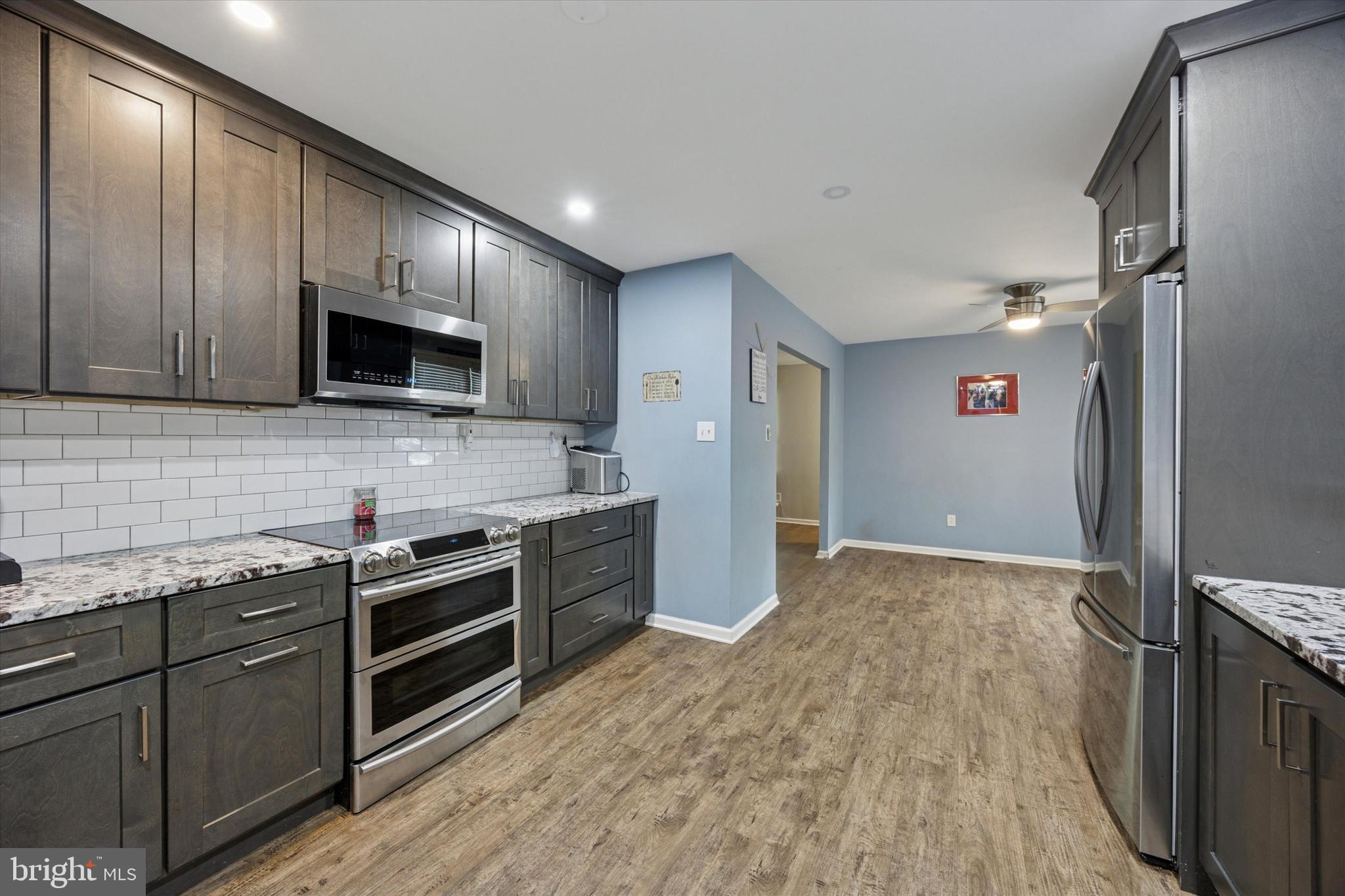 37 Millbrook Road Newark, DE 19713 - Photo 4 of 17 a kitchen with stainless steel appliances granite countertop a stove a sink and a refrigerator