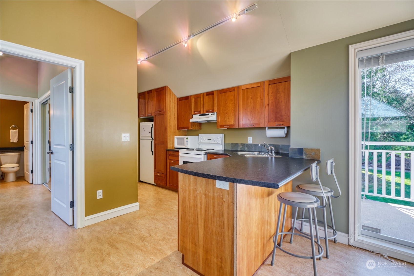 589 South Beach Road Point Roberts, WA 98281 - Photo 31 of 37 a view of a kitchen with kitchen island granite countertop wooden floor and a window