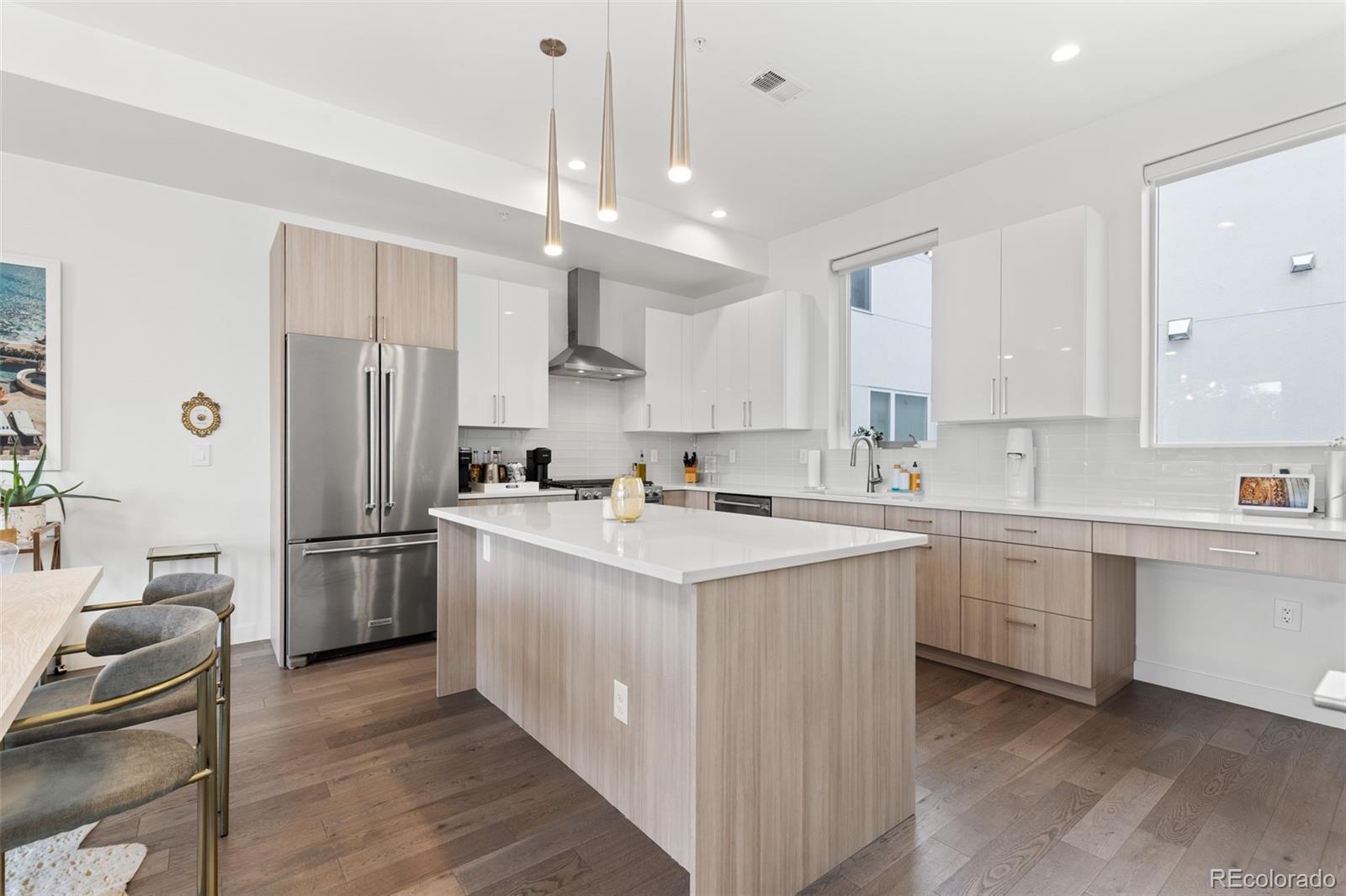 1608 Irving Street Denver, CO 80204 - Photo 12 of 37 a kitchen with white cabinets and stainless steel appliances