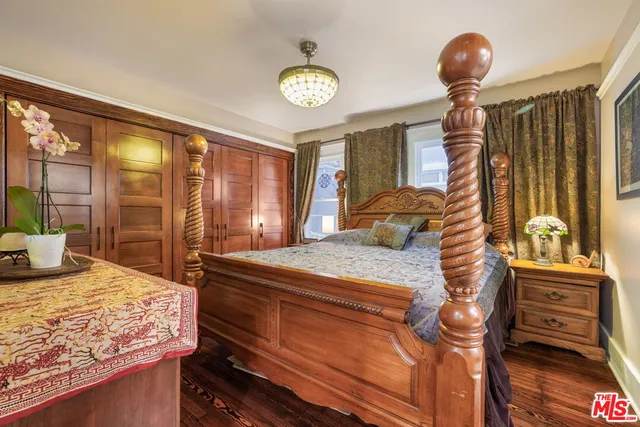 a bedroom with a bed and large windows