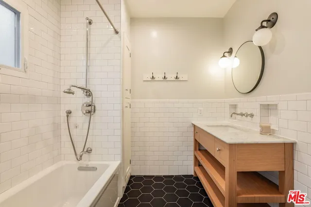 a bathroom with a sink a tub and a mirror