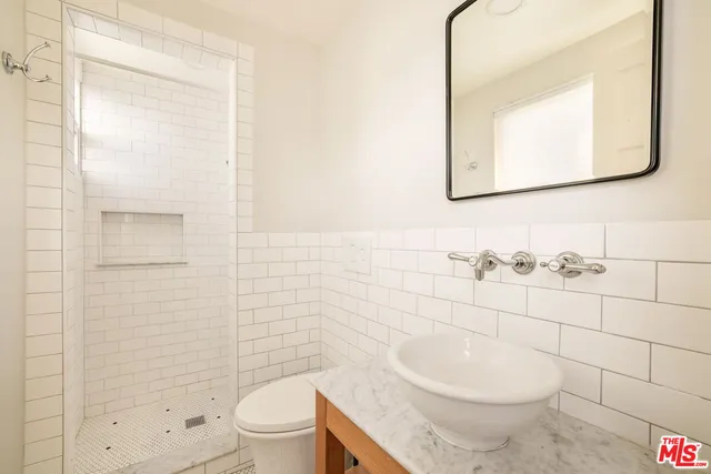 a bathroom with a toilet a sink and mirror